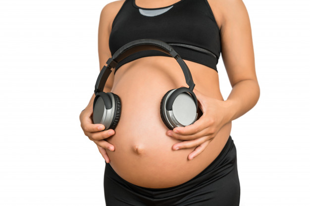 pregnant-woman-holding-headphones-belly_58466-8873